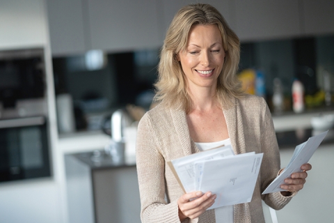Woman holding mail that she received in the post