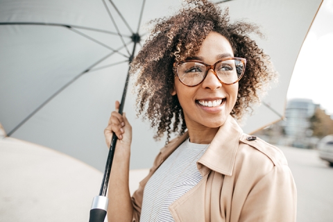 smiling woman holding an umbrella