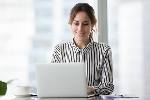 happy-woman-typing-on-laptop