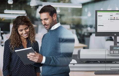 man and woman in front of mailing machine