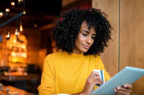 woman working on her tablet and making a payment