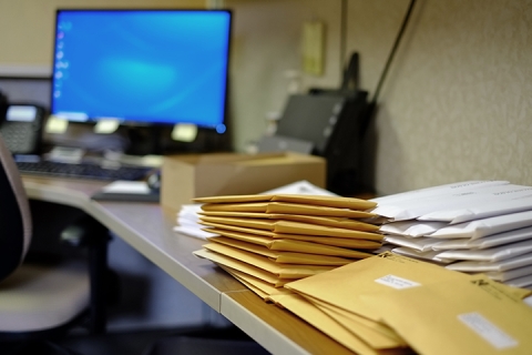 Desk with letters and packages piled on