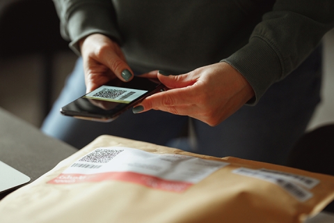 Close up on a woman scanning the QR code on a package