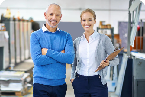 a man and a woman in an office smiling at camera