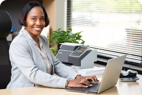 a woman using a laptop and smiling