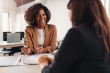 Female financial advisor consulting a client at the meeting and having business conversation or making offer