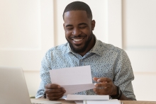 male reading a letter and smiling