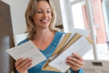 person looking at pile of mail