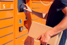 Man using automated self service post terminal machine or locker to deposit the parcel for storage