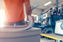 Person stacking pages of printed paper